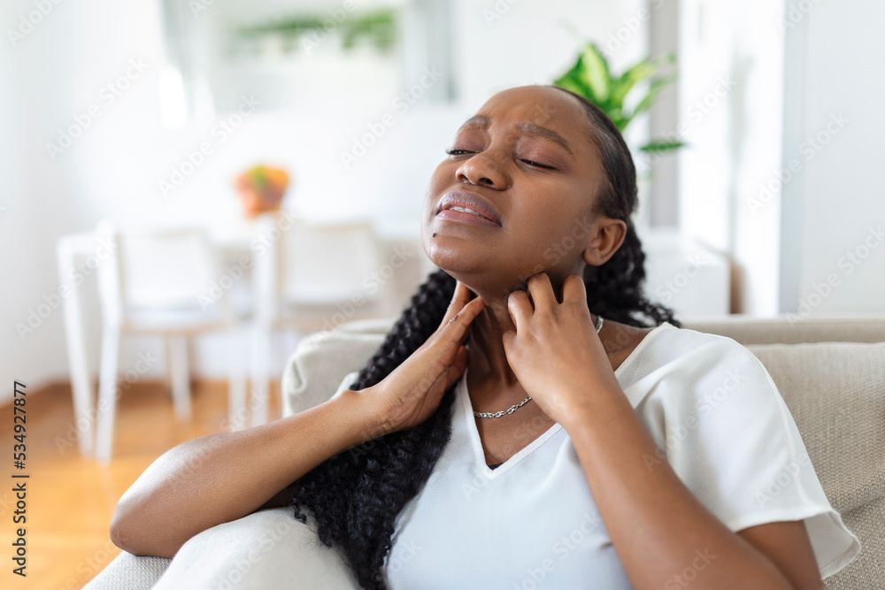 Close up of young woman rubbing her inflamed tonsils, tonsilitis problem, cropped. Woman with thyroid gland problem, touching her neck, girl has a sore throat Close up of young woman rubbing her inflamed tonsils, tonsilitis problem, cropped. Woman with thyroid gland problem, touching her neck, girl has a sore throat