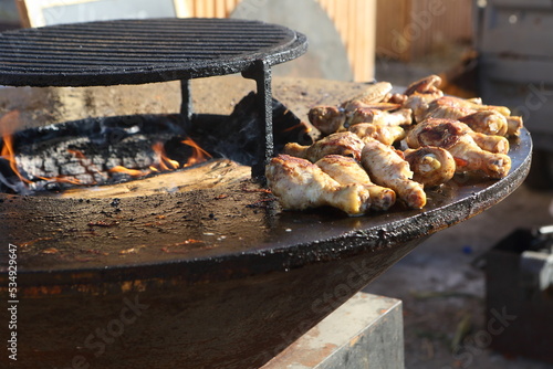 Chicken skewers being cooked outside photo