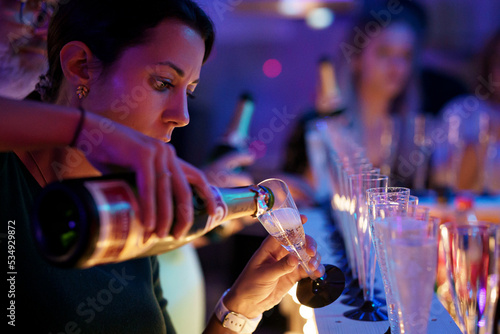 Une femme qui sert une coupe de champagne dans une fête, à Nouvel-An. photo