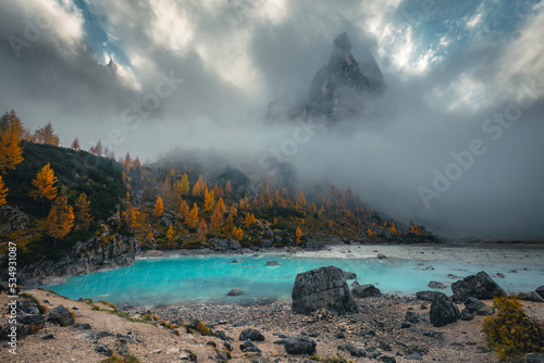Amazing lake Sorapis and misty mountains at autumn, Dolomites, Italy