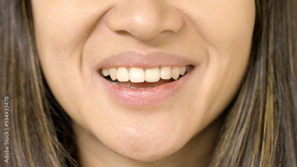 Close portrait of smiling female mouth looking straight to camera Close portrait of smiling female mouth looking straight to camera