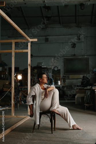 A mature woman poses in a film studio.