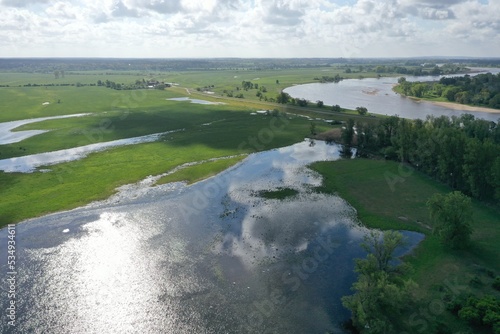 Beautiful Partly Cloudy Marshland Scene with Reflection of Clouds and Sun Next to a River in Germany taken with DJI Mavic 2 Pro