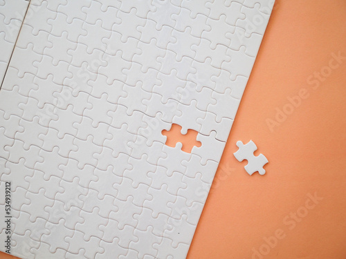 white jigsaw on orange paper photo