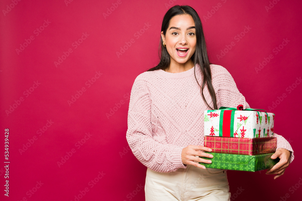 Surprised young woman receiving a lot of christmas presents Surprised young woman receiving a lot of christmas presents