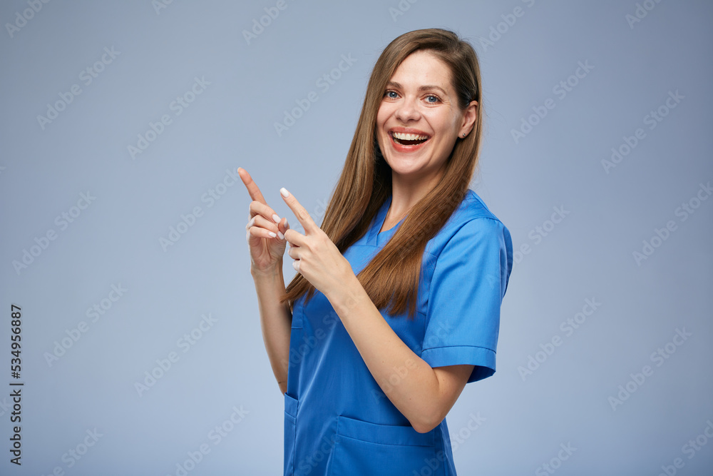 Smiling nurse woman pointing fingers up. Isolated female portrait. Smiling nurse woman pointing fingers up. Isolated female portrait.