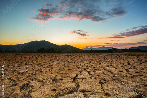 paddy fields dry out, lack of water leaves the ground cracked against the backdrop of mountains and beautiful sunsets