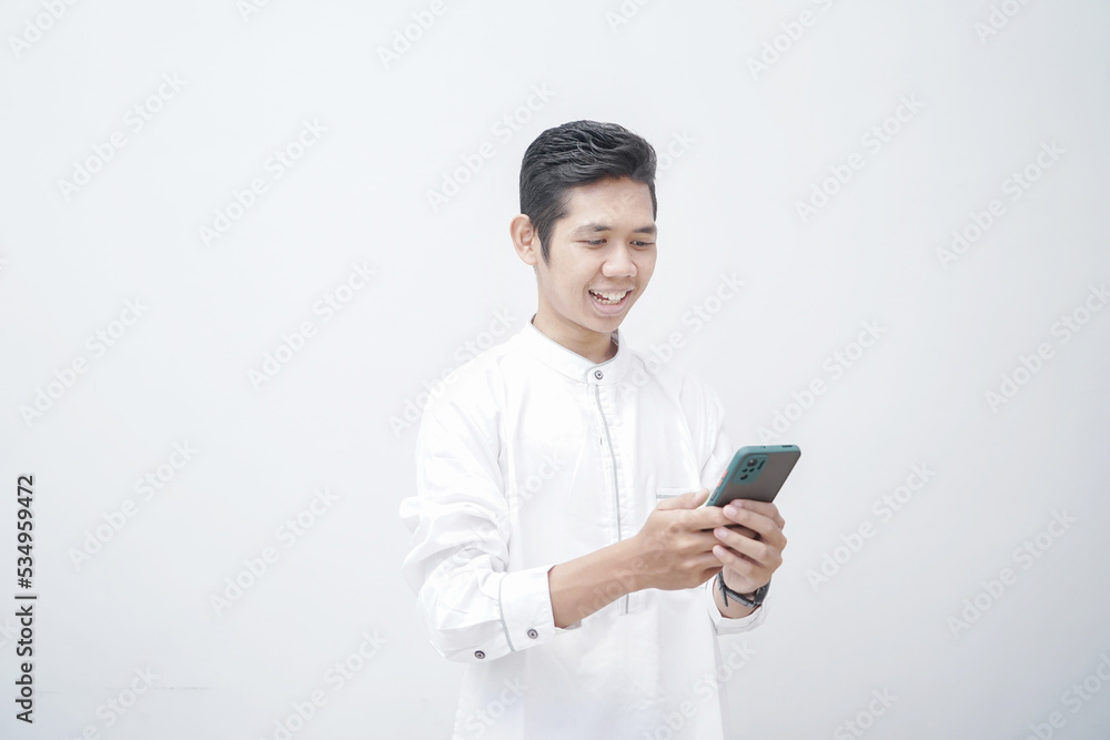 Adult Asian man looking camera while holding mobile phone showing enthusiastic expression Adult Asian man looking camera while holding mobile phone showing enthusiastic expression