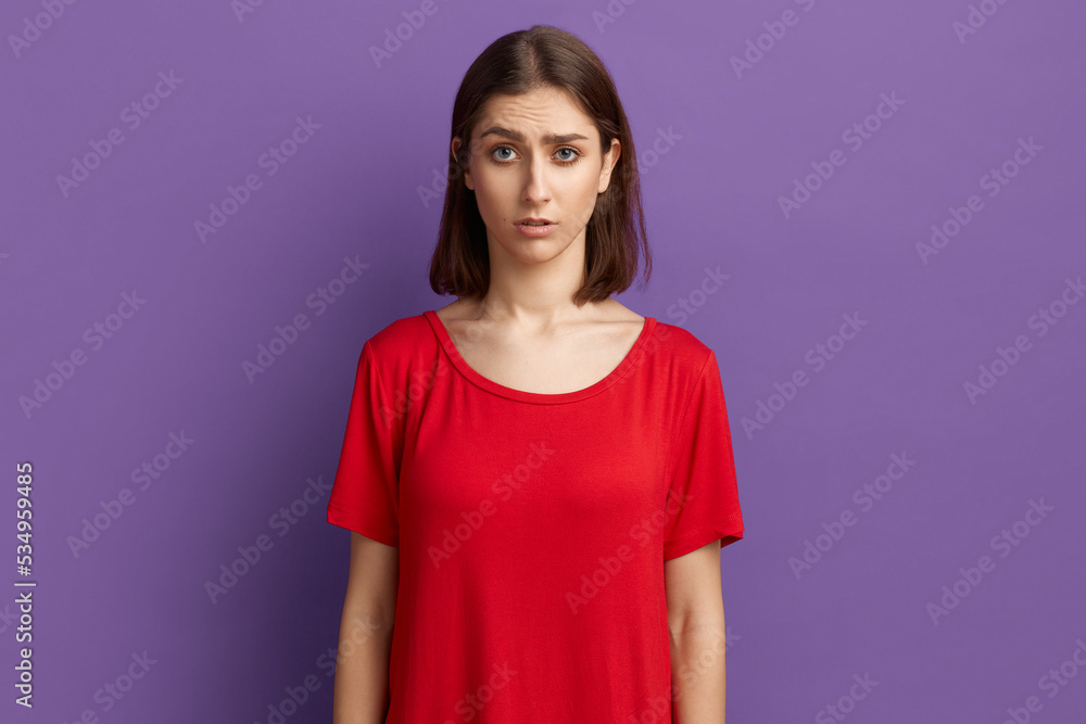 I can not believe. Surprised pretty brunette girl in red t-shirt notices something unexpected, hears bad news. Looks with horror at the camera. Posing over purple background. I can not believe. Surprised pretty brunette girl in red t-shirt notices something unexpected, hears bad news. Looks with horror at the camera. Posing over purple background.