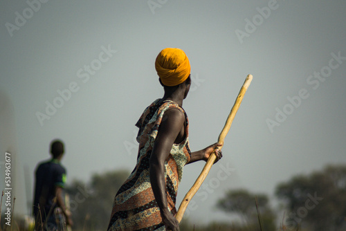 Fototapet African woman on boat in okavango delta with stick guiding