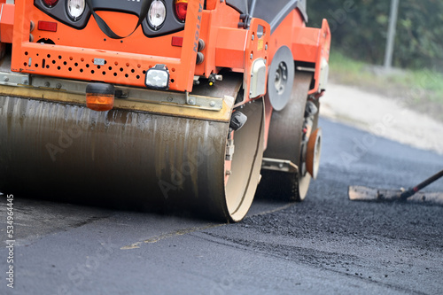 A road roller compacts asphalt at a road construction site © Spitzi-Foto