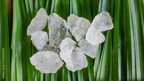 Crystal clear alum cubes or Potassium alum on green leaf. Chemical compound substance. Concept for beauty , spa and underarm treatment industrial.                                 photo