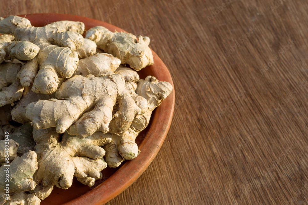 ginger on a clay plate on a wooden background ginger on a clay plate on a wooden background