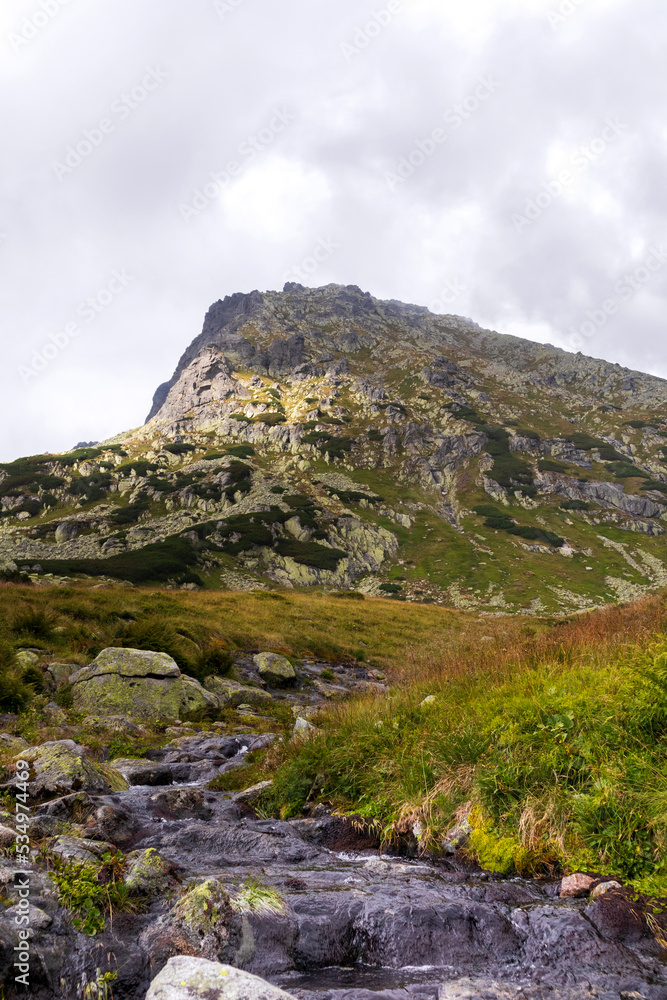Impressive landscape with large grey-brown mountains in the Polish Tartars with a rocky hiking path