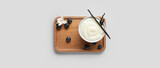 Bowl of pudding, vanilla sticks and blueberries on light background, top view