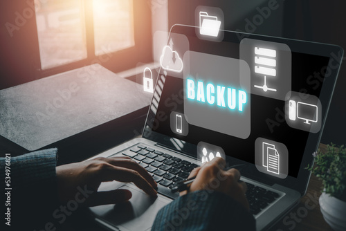 Backup storage data internet technology business concept, Business woman using a computer with VR screen backup icon on desk. photo