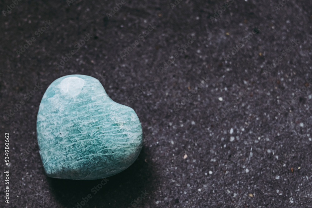 Obraz premium Pierre polie amazonite en forme de coeur sur un fond noir - Minéral naturel