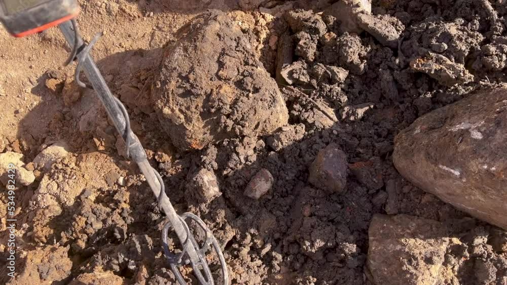 overhead close up of metal detector coil searching for treasure in dirt overhead close up of metal detector coil searching for treasure in dirt