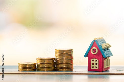 House model and stack gold coin with working capital management in the public park, Saving money for real estate and loan for buy home for investment concept.