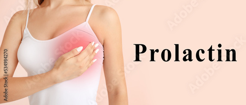Young woman checking her breast on pink background. Prolactin and women's health