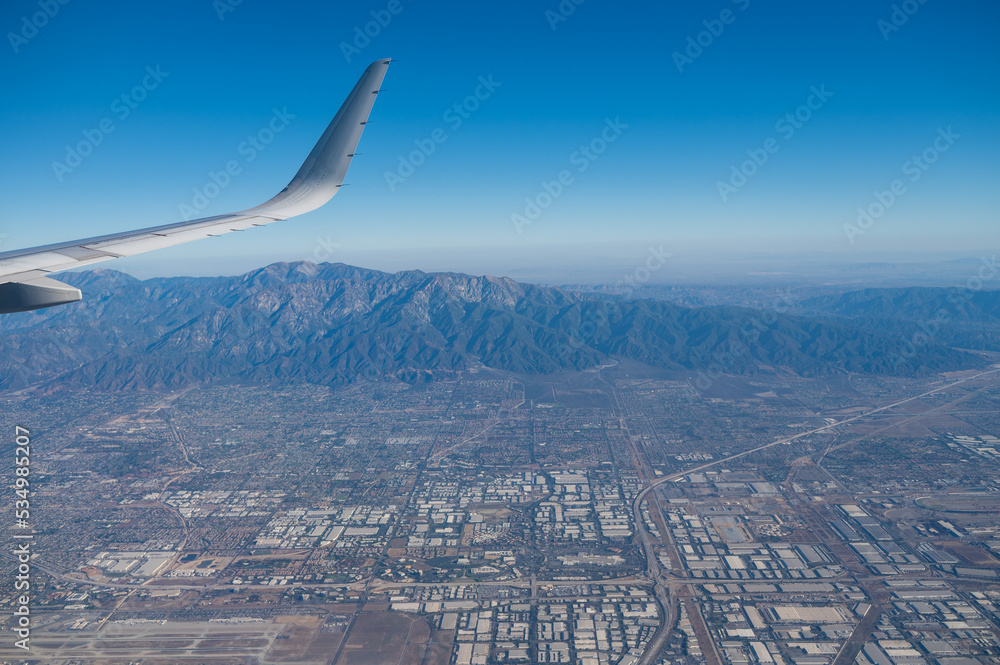 Airplane wing seen flying over Los Angeles