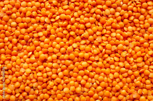 Red lentil grains background, texture, top view. Dry grains of red lentils, background, top view. Orange lentils, background. Bunch of orange lentils, texture, top view.