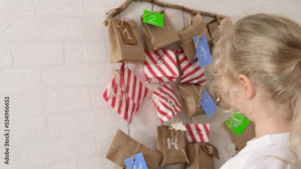 cute curly girl with blond hair and advent calendar, homemade gift