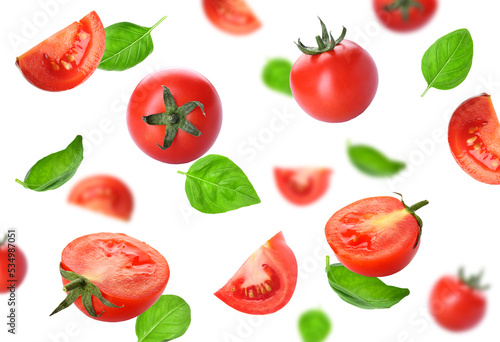 Fresh flying tomatoes and basil isolated on white