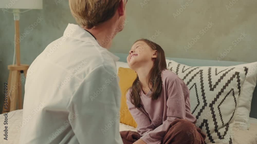 The doctor plays with an Asian girl and wishes her well. The doctor plays with an Asian girl and wishes her well.