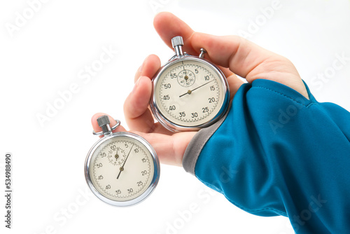 Two mechanical stopwatches hang on the fingers of a male hand. Time part precision. Measurement of the speed interval photo