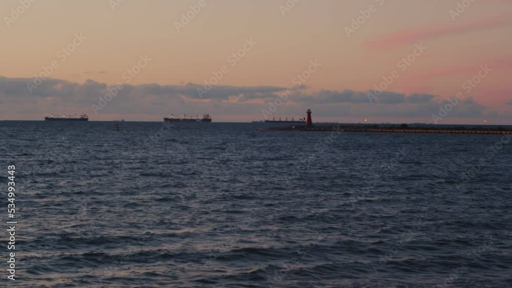 Time Lapse Seascape with a lighthouse and water transport, ships and yachts enter the harbor at dusk after sunset. Gdansk, Poland. Time Lapse Seascape with a lighthouse and water transport, ships and yachts enter the harbor at dusk after sunset. Gdansk, Poland.