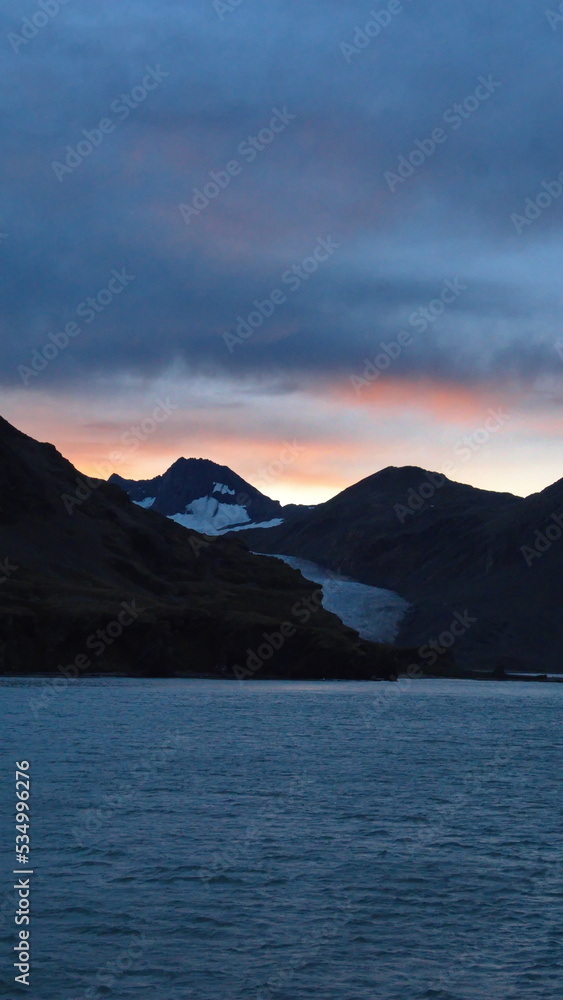 Sunset over a glacier in the mountains near Fortuna Bay, South Georgia Island