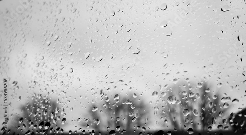 Grey autumn rainy day outside with rain drops on the window glass