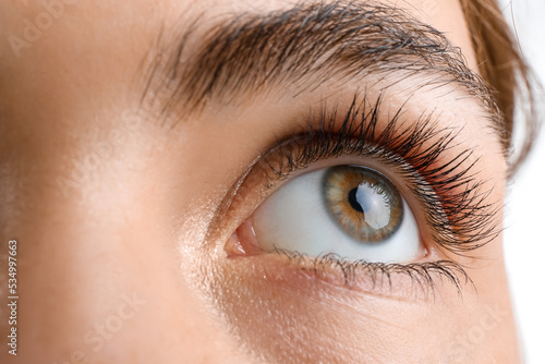 Young woman with beautiful hazel eyes on white background, closeup