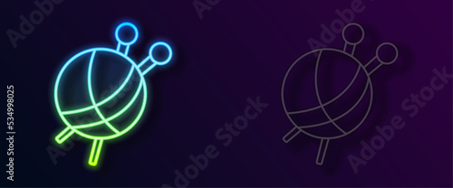 Glowing neon line Yarn ball with knitting needles icon isolated on black background. Label for hand made, knitting or tailor shop. Vector