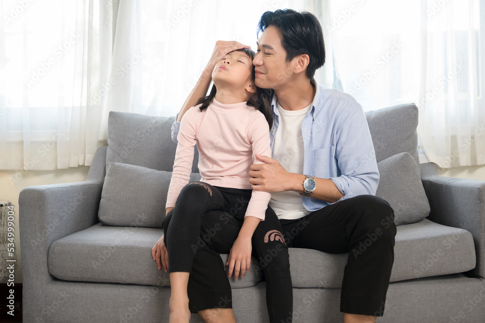 Portrait of asian father and daughter sitting on couch in the living room Portrait of asian father and daughter sitting on couch in the living room