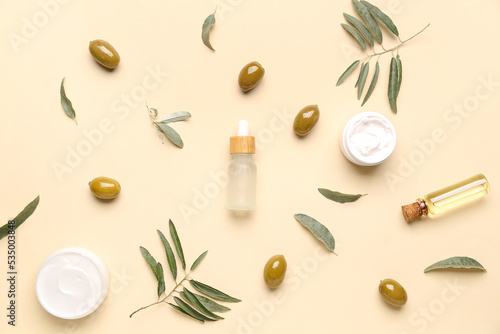 Composition with natural olive cosmetics and plant leaves on color background