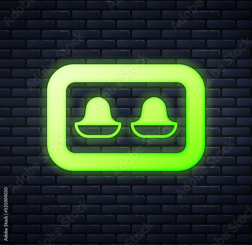 Glowing neon Earplugs with storage box icon isolated on brick wall background. Ear plug sign. Noise symbol. Sleeping quality concept. Vector