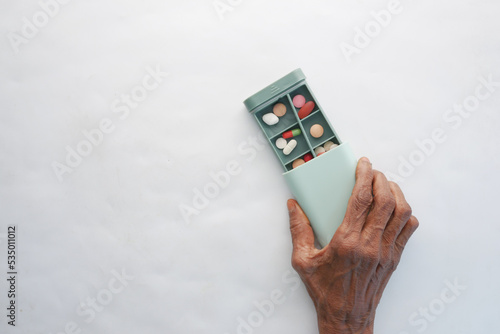 senior women holding a medical pills box on white background  photo