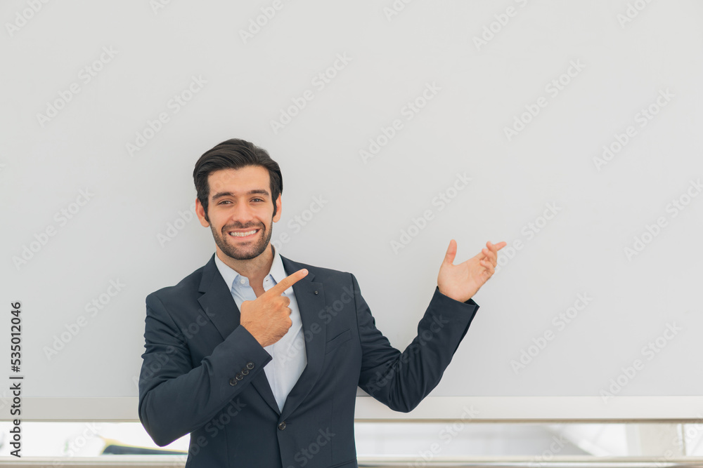 Portrait of cheerful businessman handsome attractive pointing on empty blank copy-space isolate grey background Portrait of cheerful businessman handsome attractive pointing on empty blank copy-space isolate grey background
