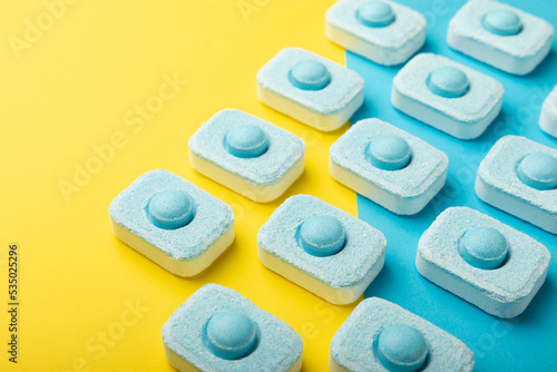 Tablets for softening water on a yellow background. Capsules for washing machines and dishwashers, preventing limescale. Place to copy.