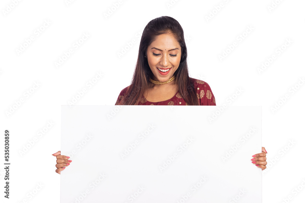 Cheerful Indian young woman holding white board on white background. Cheerful Indian young woman holding white board on white background.
