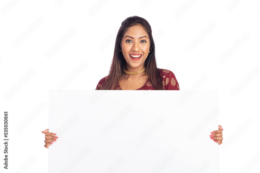 Cheerful Indian young woman holding white board on white background. Cheerful Indian young woman holding white board on white background.