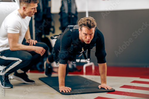 Man Doing Plank Exercise During EMS Workout In The Gym