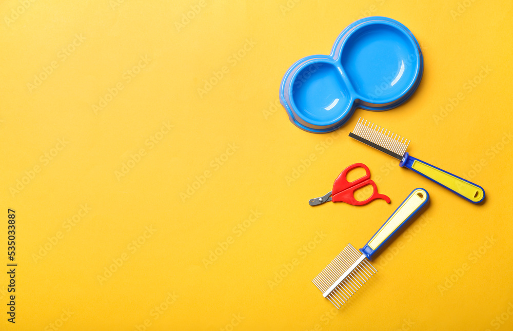 Pet bowl, grooming combs and nail clipper on color background Pet bowl, grooming combs and nail clipper on color background