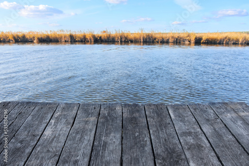 Closeup view of wooden pier near river on autumn day