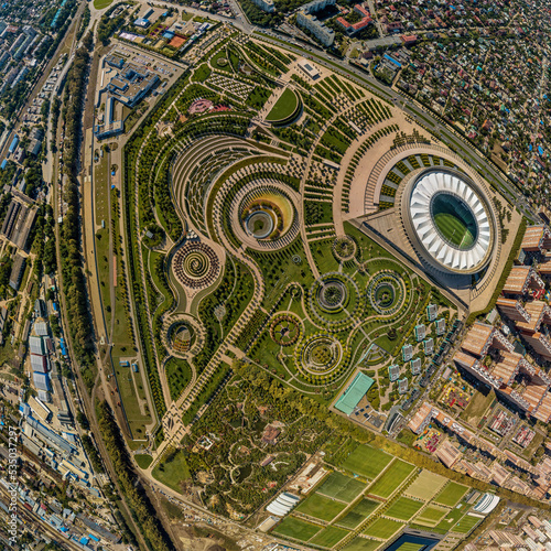 urban regular park on the northeastern outskirts of the city of Krasnodar and a snow-white stadium. Aerial panorama on a sunny day in early autumn