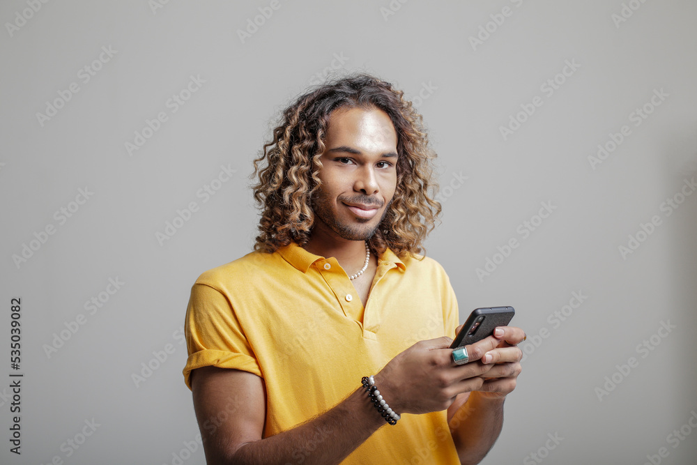 Portrait of a man, using phone, in front of a background Portrait of a man, using phone, in front of a background