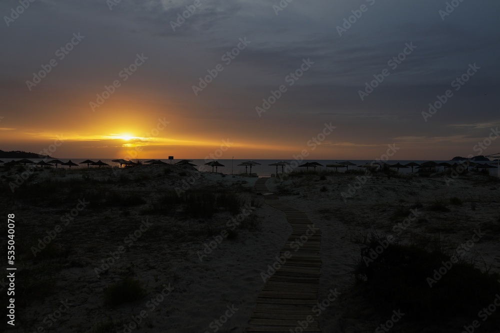 Summer sunrise over Golden Beach (Skala Potamias) in Greece with an overcast sky.