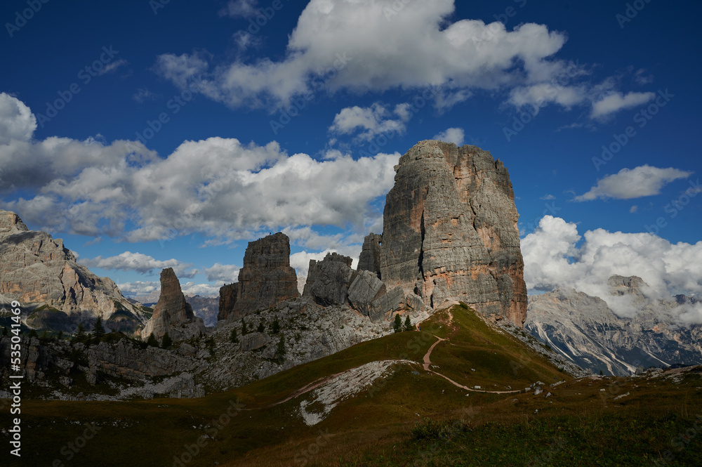 Cinque Torri in Dolomites, stunning panoramic view on Five Towers group, overcast sky and foot road. Amazing nature lanscape background.  South Tyrol Italian, Alps, Italy, Europe